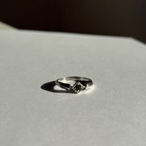 Pierścionek o geometrycznym kształcie z zielonym kamieniem